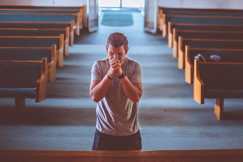 man standing near altar praying